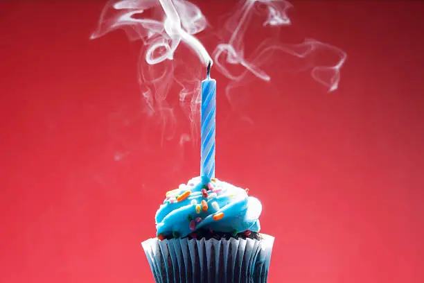 Photo of Birthday cupcake on red background