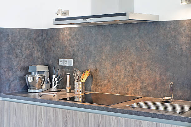 New modern gray kitchen with utensils next to range hood