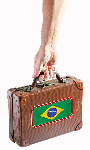 Hand holding antique leather suitcase with Brazil flag