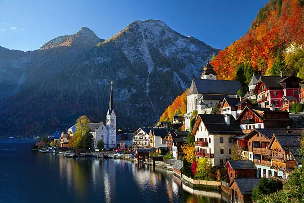 Image of famous alpine village Halstatt during colourful fall morning.
