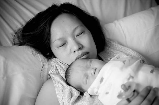 istock Exhausted mother holding her newborn baby 468215867