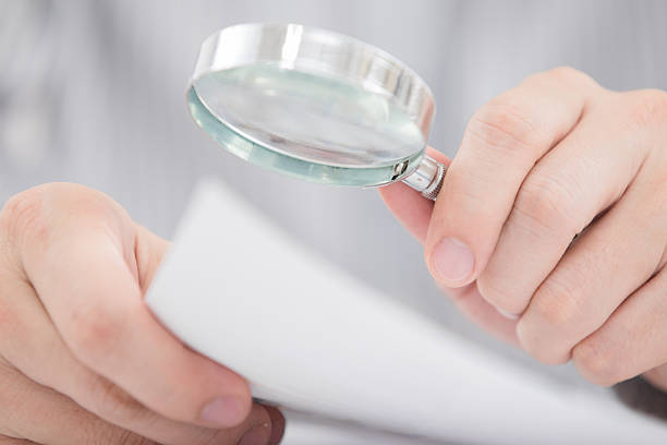 istock Businessman looking through a magnifying glass 468217027