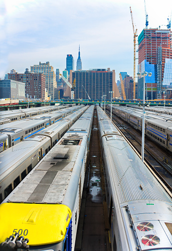 New York City, USA - March 11, 2015: Many trains in a Long Island Railroad parking facility at the west-end of Manhattan, overlooking mid-town and the Empire State Building