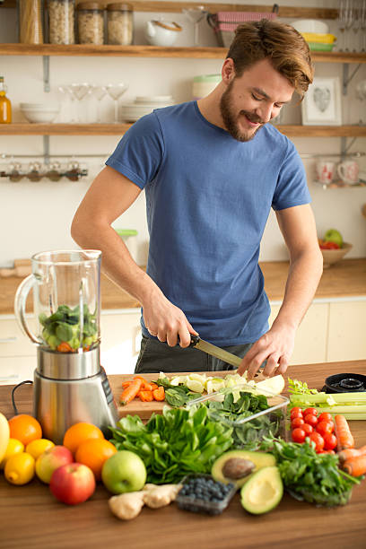 istock Young man making juice or smoothie in kitchen. 468231952