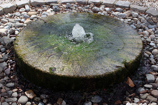 An old mill stone was used to construct a garden fountain.