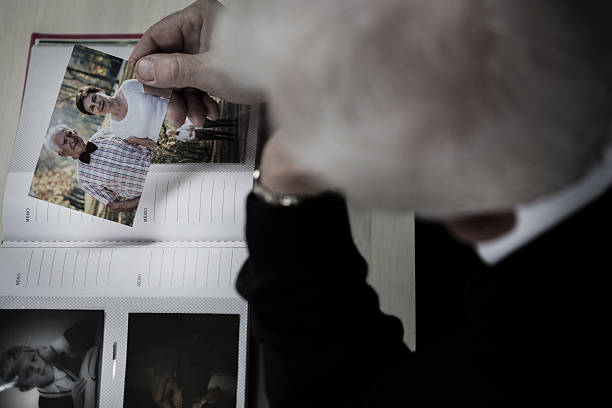 istock Windowed man watching photo album 468235406