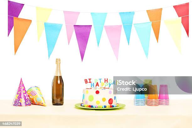 Bottle Of Champagne Plastic Glasses Party Hats And Birthday Cake Stock Photo - Download Image Now