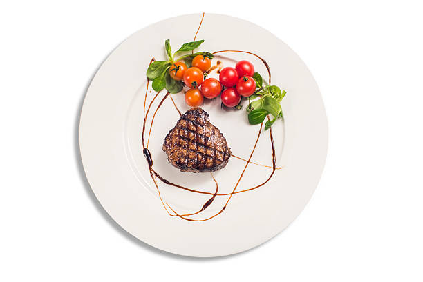 Grilled sirloin steak with tomatoes isolated on white plate