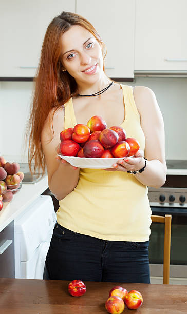 woman with nectarines in  kitchen