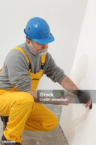 Electrician At Construction Site Testing Installation Stock Photo - Download Image Now
