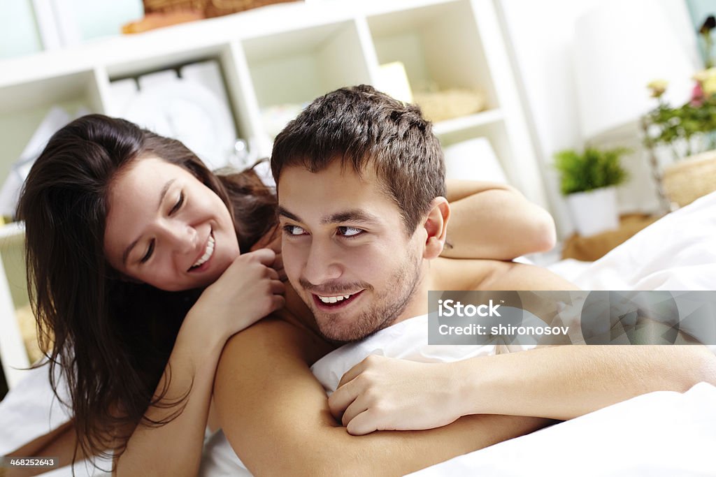 Lying in bed Happy young couple lying in bed Adult Stock Photo