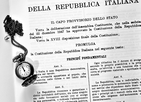 text of the Italian constitution with an old black and white pocket watch on it