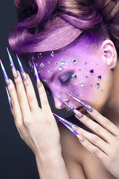 istock Girl with purple creative makeup with crystals and long nails. 468263896