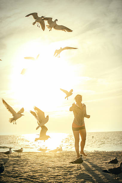 istock Woman feeding seagulls on the beach 468271584
