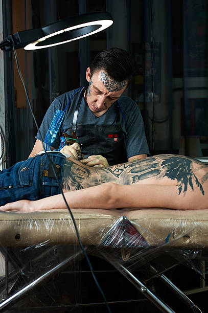 istock Tattoo artist makes a tattoo in studio 468272186