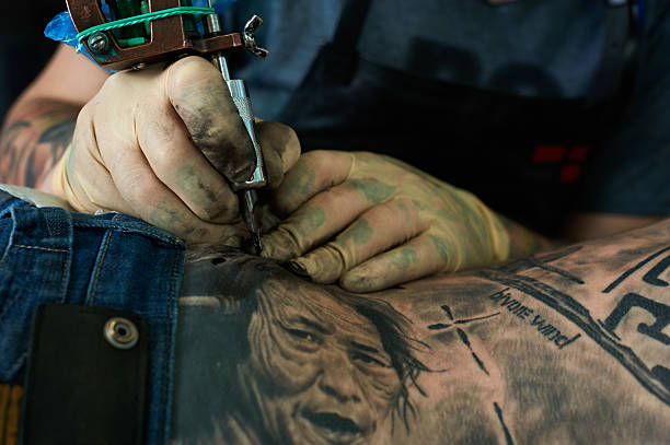 Working hands of tattoo master Working hands of tattoo master. Closeup shoulder tattoo designs for men stock pictures, royalty-free photos & images