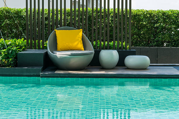 Relaxing chairs with pillows beside swimming pool stock photo