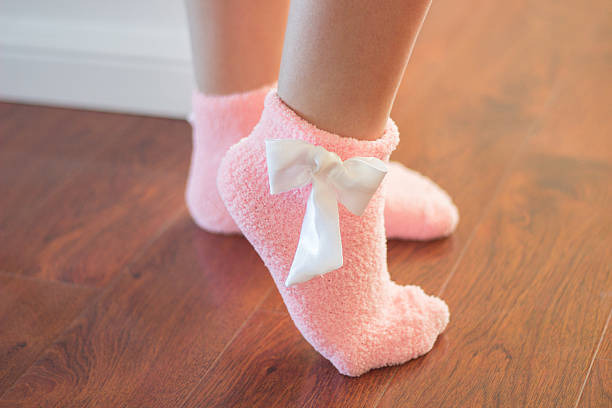 istock Female feet in pink socks 468277352