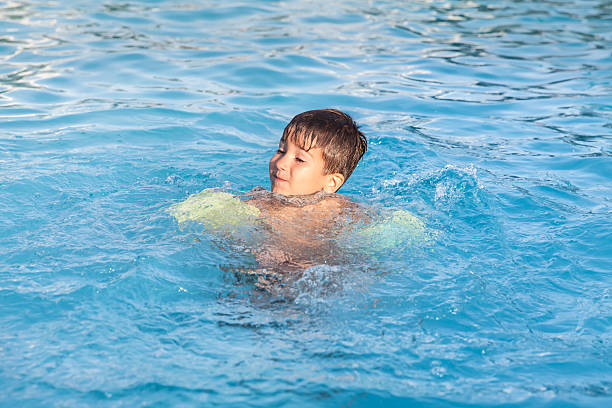 istock Little boy learning to swim in the pool 468279215