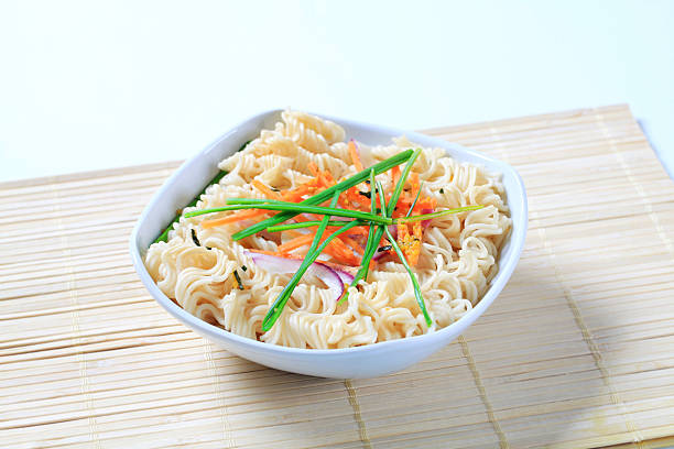 Tasty instant noodles with vegetables in a bowl