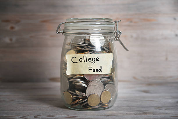 Coins in jar with college fund label Coins in glass jar with college fund label, financial concept. Vintage wooden background with dramatic light. coins of ringgit of malaysia stock pictures, royalty-free photos & images