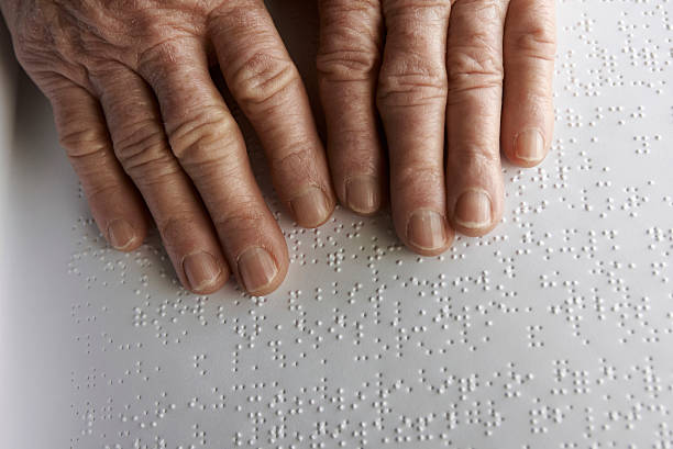 istock Old womans hands, reading a book with braille language 468289977