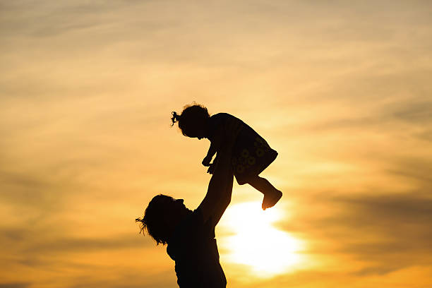 istock Father and little daughter silhouettes at sunset 468290932