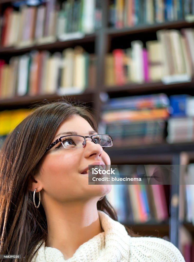 Mujer joven de pie en la biblioteca - Foto de stock de 2015 libre de derechos