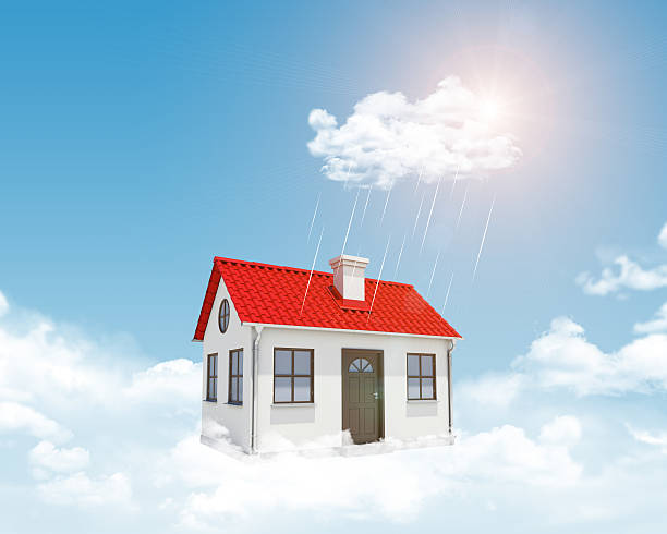 istock White house with red roof, chimney in clouds. Background sun 468299634