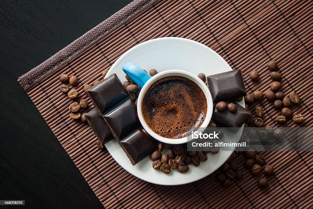 Turkish Coffee from top Turkish traditional drink in blue porcelain and chocolate bar between coffee beans on wooden food service Coffee - Drink Stock Photo