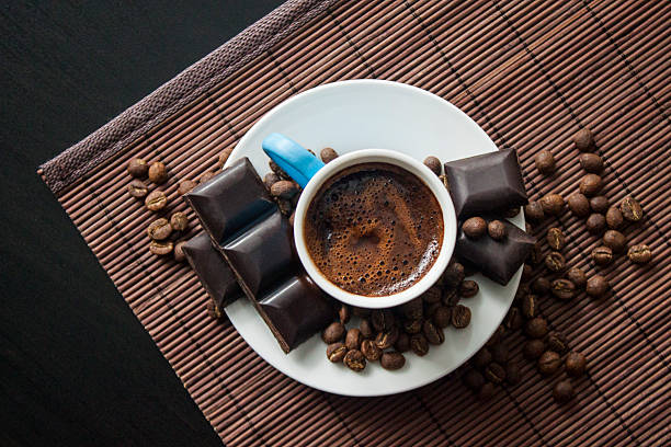 Turkish Coffee from top Turkish traditional drink in blue porcelain and chocolate bar between coffee beans on wooden food service mocha stock pictures, royalty-free photos & images