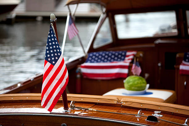 American flags adorn a classic wooden boat at anchor stock photo