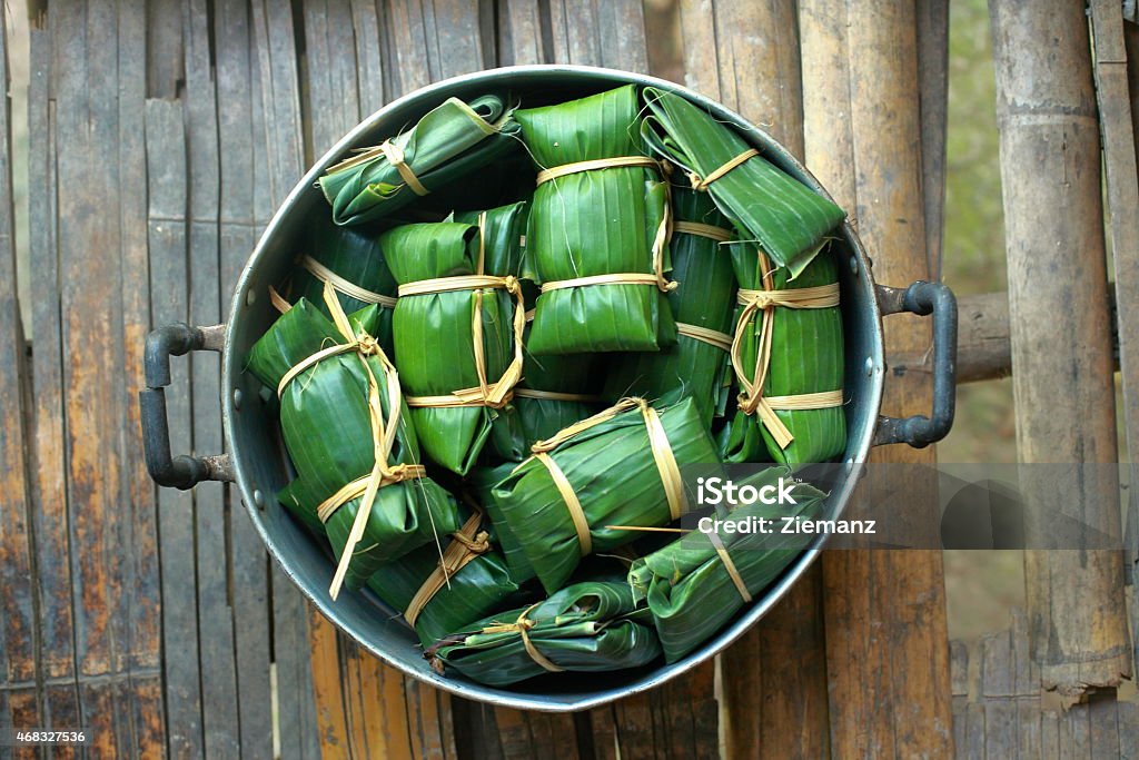 Thai dessert wrapped in banana leaves Thai dessert made from rice,Black Peas and banana wrapped in banana leaves and steam. 2015 Stock Photo