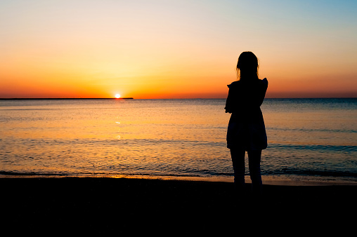 Silhouette of woman watching the sunrise