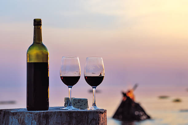 istock Two wine glasses with red wine overlooking a beach scene 468327934