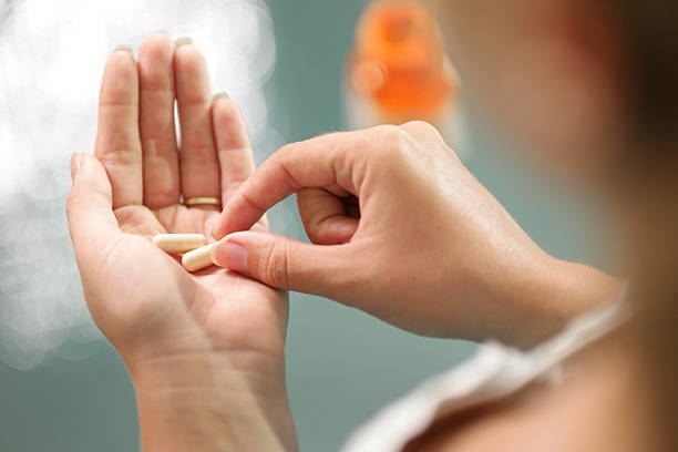 ginseng jeune femme prenant des vitamines en cachets - activité avec mouvement photos et images de collection