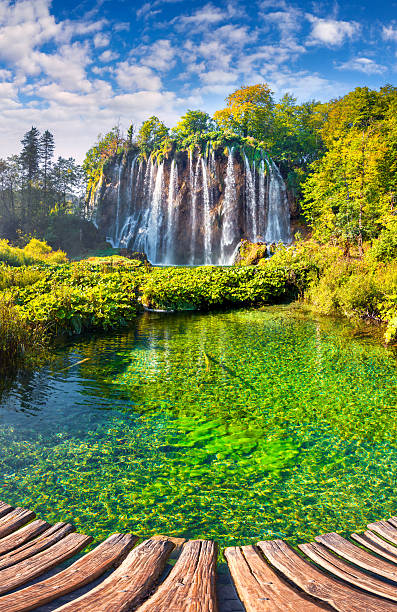 bela pedra com uma cascata sob o céu azul. - natural phenomenon waterfall rock tranquil scene imagens e fotografias de stock