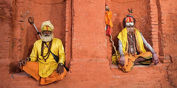 Sadhu - indian holymen sitting in the temple In Hinduism, sadhu, or shadhu is a common term for a mystic, an ascetic, practitioner of yoga (yogi) and/or wandering monks. The sadhu is solely dedicated to achieving the fourth and final Hindu goal of life, moksha (liberation), through meditation and contemplation of Brahman. Sadhus often wear ochre-colored clothing, symbolizing renunciation.http://bem.2be.pl/IS/nepal_380.jpg varanasi stock pictures, royalty-free photos & images