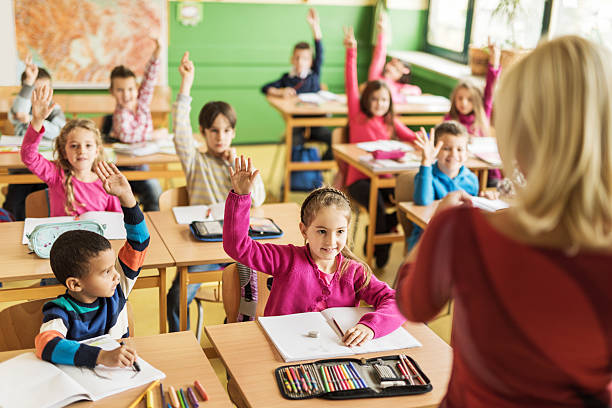 istock School children raising their hands ready to answer the question. 468332264