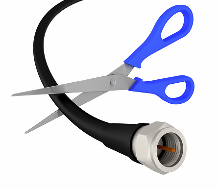 Scissors cut through a coaxial cable on white - cutting the cord tv concept