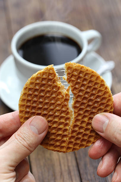 stroopwafel split by hands - stroopwafel stockfoto's en -beelden