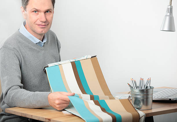 istock Designer offering samples of fabric to client 468336330