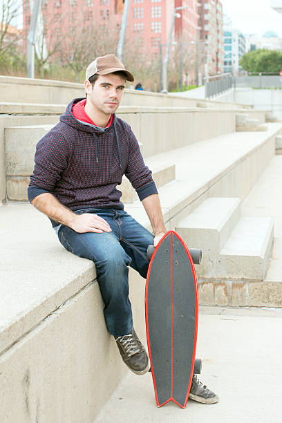 istock Man sitting in the street with skateboard. 468338921
