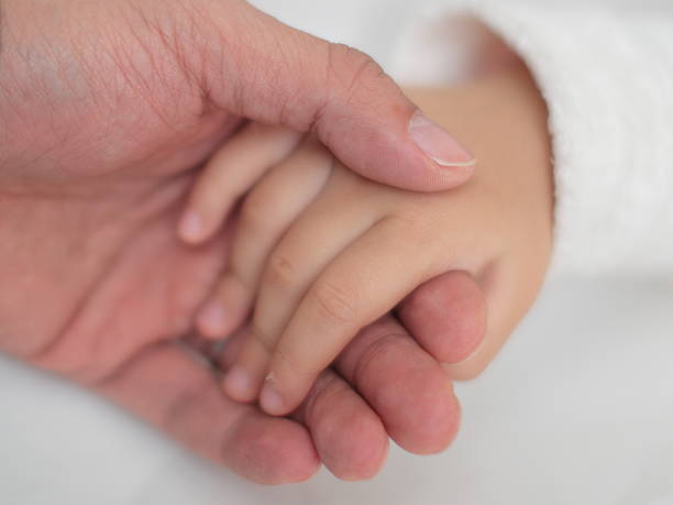istock father and baby hands 468339047