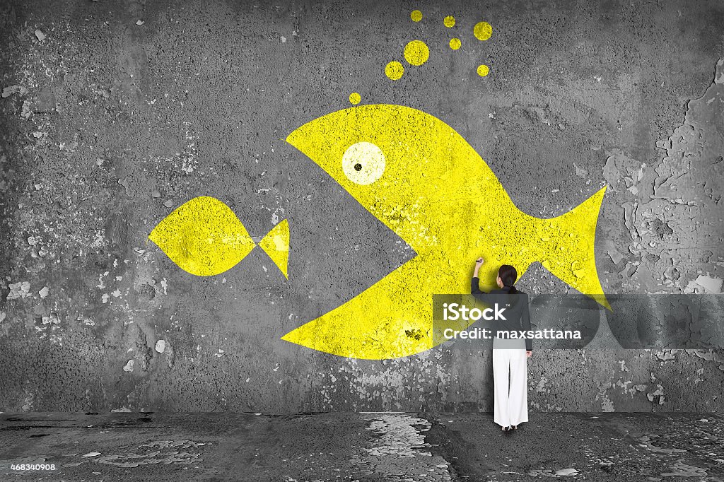 businesswoman drawing  big fish  on the wall Fish Stock Photo