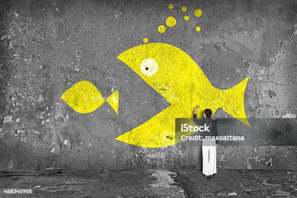 Businesswoman Drawing Big Fish On The Wall Stock Photo - Download Image Now - Fish, Large, Small