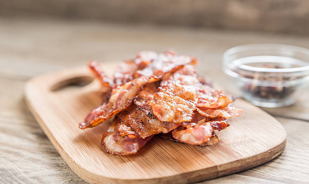 istock Stack of fried bacon strips on the wooden board 468341150