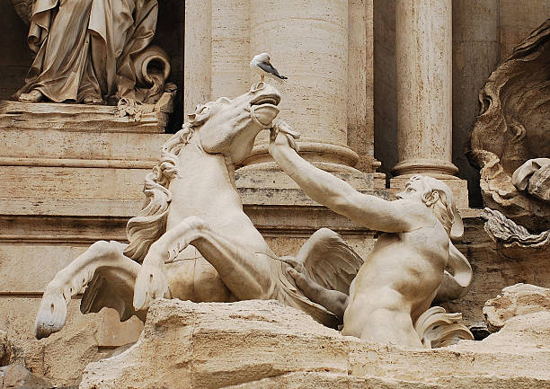 Details of the left hand Triton and horse in the Baroque Trevi Fountain in Rome. The horse is being calmed by the Triton.