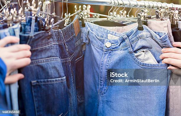 Hands Looking For Pants Jeans On A Flea Market Stock Photo - Download Image Now - Thrift Store, Jeans, 2015