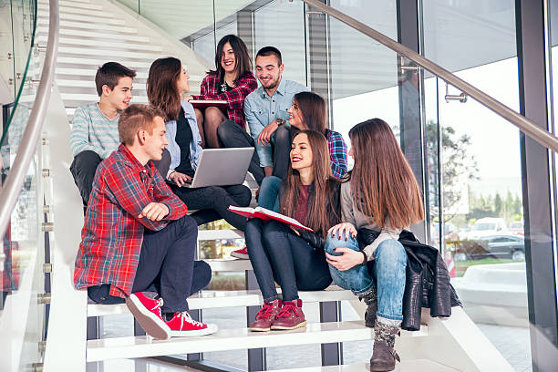 grupo mediano de los estudiantes de la escuela estudiando en pasos del hotel. - face to face teenage couple teenager couple fotografías e imágenes de stock